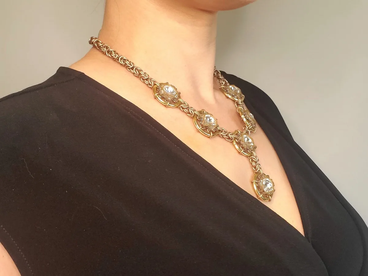 Angled view of the Galaxy and Stardust necklace in a warm gold-tone finish