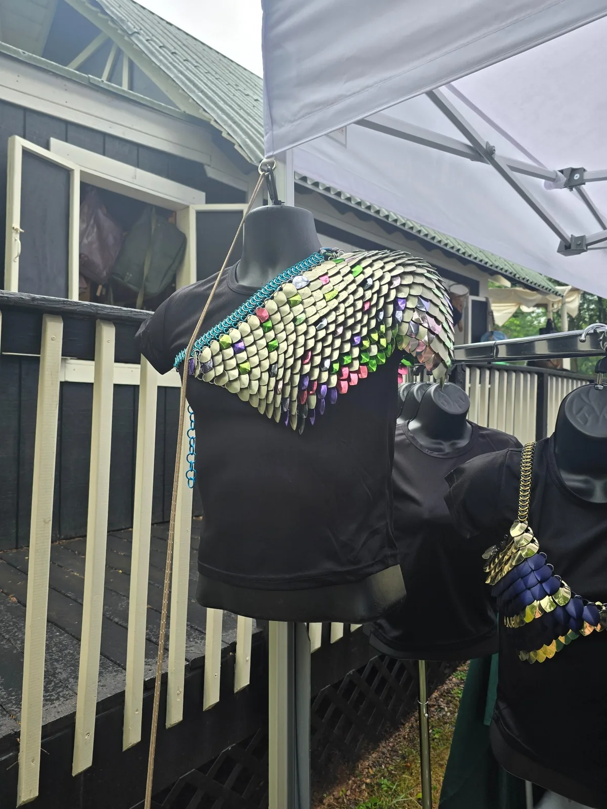 Iridescent one-shoulder scale drape displayed on a mannequin
