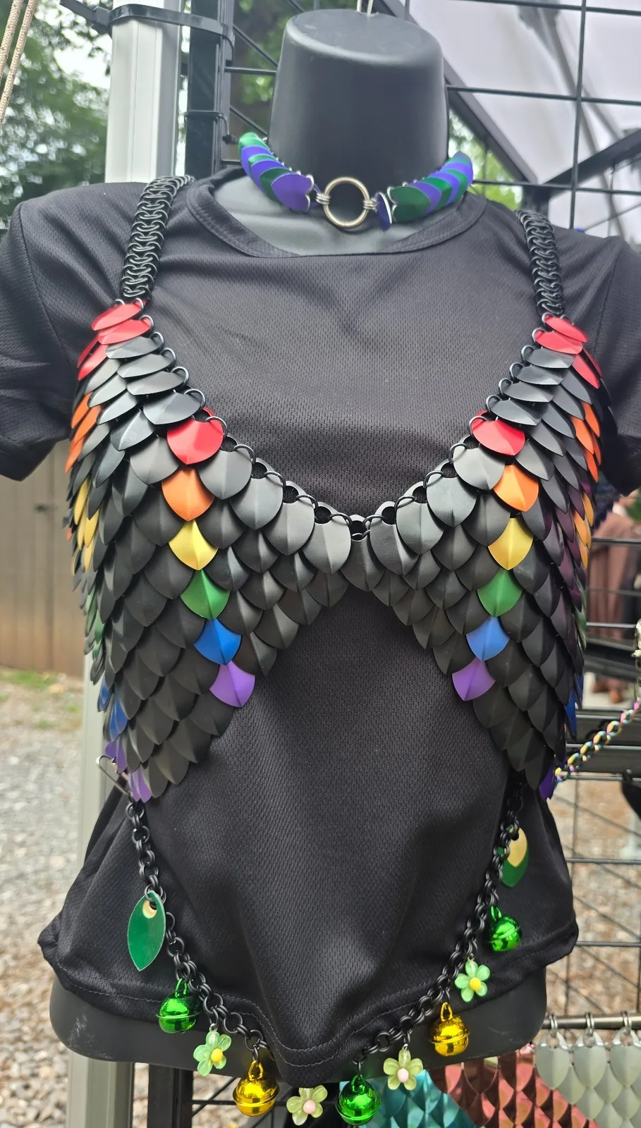 Black scale top with rainbow accents and decorative charms on a mannequin