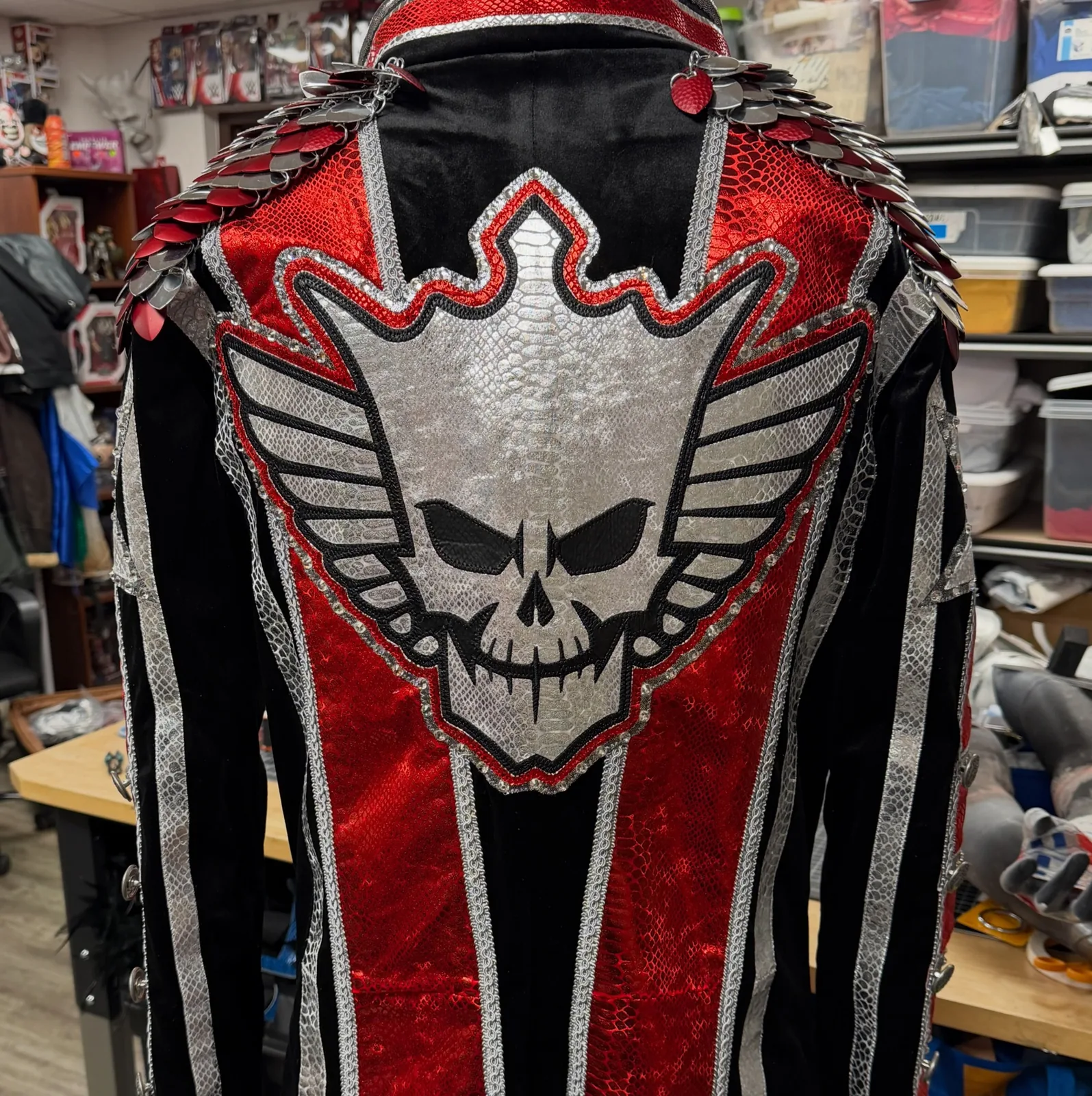 Back view of red, black, and silver Cody Rhodes entrance coat with scale shoulder pieces and winged skull design