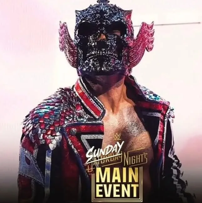 Cody Rhodes wearing a black skull mask and red, black, and silver entrance coat with scale shoulders